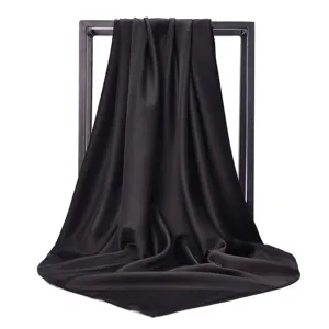 Macro view showing smooth dark satin silk square scarf draped over minimalist frame