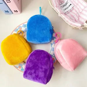 Close-up of four colorful plush backpack-shaped coin purses with hanging hooks.