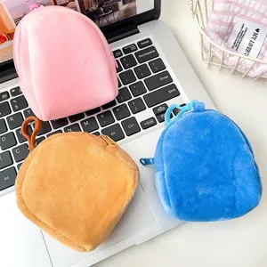 Close-up detail of three colorful plush mini backpack coin purses for earphone storage