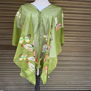 Detailed close-up of green butterfly print sheer sun protection shawl with pearl buttons