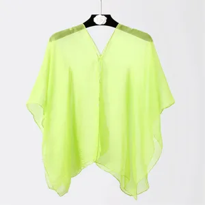 Detailed macro view of sheer neon green chiffon beach cover-up featuring delicate button closure