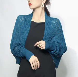 Detailed view of elegant teal honeycomb knit shrug shawl on model wearing a black dress
