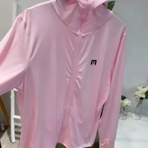 Detail of pink hooded sun protection jacket with breathable fabric and thumbholes