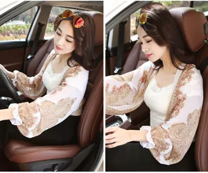 Close-up detail of patterned chiffon sun protection shawl worn by a woman driving