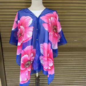 Detailansicht eines blauen Chiffon-Schals mit großen rosa Blumendrucken und Perlen