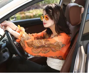 Model wearing orange paisley sun protection chiffon shawl while driving in a car