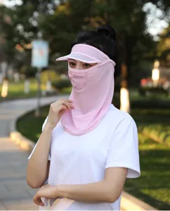 Asian woman wearing a pink UV protection mask with integrated sun visor in a park.