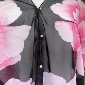 Detailansicht der Perlenknöpfe an einem Chiffon-Sonnenschutzschal mit Blumen