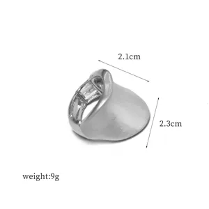 Primer plano de un anillo elástico de metal plateado con superficie curva y medidas