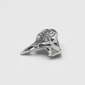 Macro detail of a vintage Nordic Viking crow skull ring with engraved runes and symbols