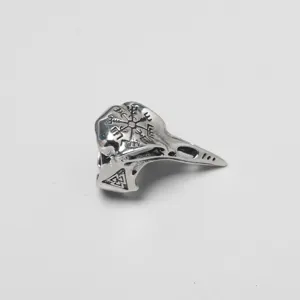 Detailed close-up of a vintage silver Viking crow skull ring with Nordic rune engravings
