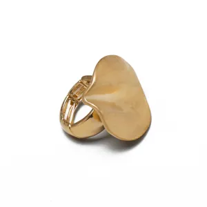 Detalle de cerca de un anillo elástico de metal dorado con un diseño de pétalo irregular