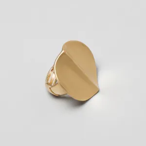 Detalle de un anillo ovalado de metal dorado con una banda elástica flexible y extensible