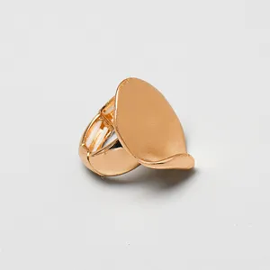Imagen macro detallada de un anillo elástico ovalado dorado con acabado de metal cepillado