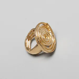 Primer plano de anillo elástico dorado con cara ovalada de diseño en espiral texturizada