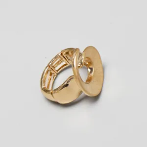 Primer plano detallado de un anillo elástico de metal dorado con diseño de disco ovalado.