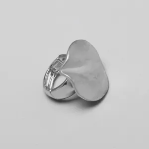 Primer plano de un anillo de pétalo elástico plateado con diseño de placa ondulada