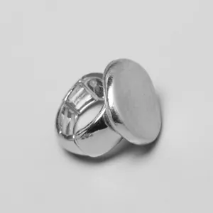 Primer plano de un anillo elástico ovalado plateado con un diseño de banda metálica extensible