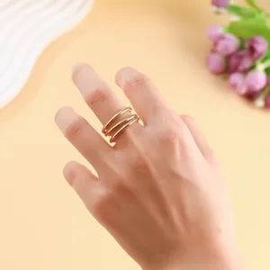 Detailed view of a golden triple-layer stacked ring on a hand model.
