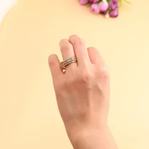 Detailed view of a minimalist three-layer stacked gold-finish ring on a finger
