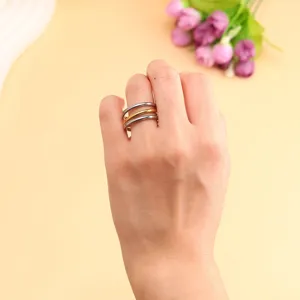 Macro shot of three-layer stacked stainless steel rings in gold and silver on hand