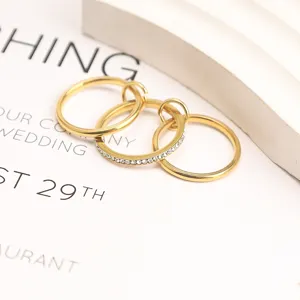 Close-up macro view of minimalist triple-layer gold-plated rings with clear stones