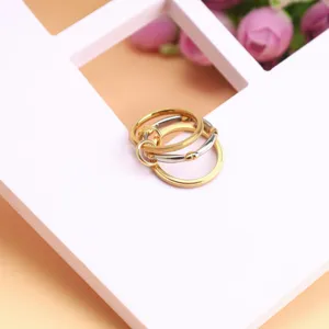 Close-up of minimalist three-layer stacked titanium steel ring in gold and silver.