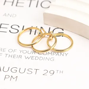 Close-up of minimalist gold-plated titanium steel stacked rings on aesthetic background paper