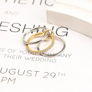Close-up of three interlocking minimalist titanium steel rings with crystal details.