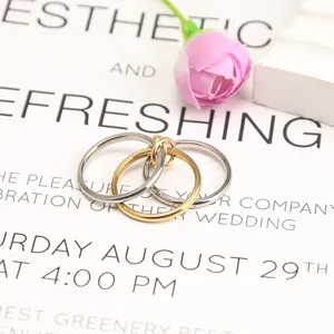 Close-up of triple-layer interlocking rings in polished gold and silver finish