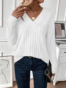 Detail of a chic white ribbed V-neck knit top accented with a gold coin necklace