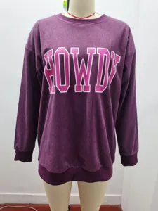 Detailansicht eines lila Damen-Cord-Sweatshirts mit rosa HOWDY-Buchstabenaufdruck