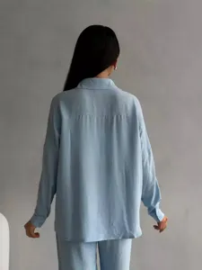 Vista posteriore di un set da donna con camicia a maniche lunghe e pantaloni a gamba larga