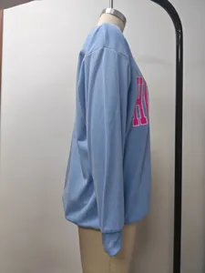Seitenansicht eines hellblauen Damen-Sweatshirts mit Rippmuster und markantem rosa Buchstabendruck
