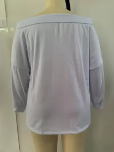 Back view of a white off-the-shoulder loose long-sleeve sweatshirt on a mannequin.