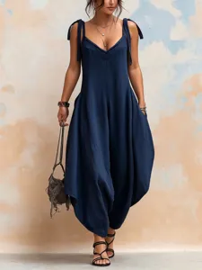 Detailed macro view of navy blue loose-fit wide-leg jumpsuit featuring V-neck and straps