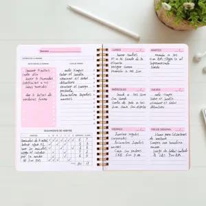 Close-up of pink weekly planner inner pages with Spanish text and spiral binding