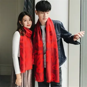 Couple wearing classic red festive cashmere scarves with Chinese Fu character blessing pattern