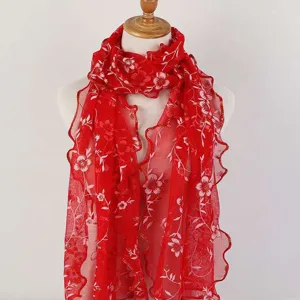 Detailed view of red floral lace scarf featuring elegant ruffle edges and embroidery