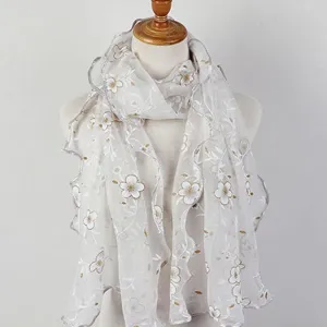 Detailed view of the elegant floral printed scarf with ruffled edges and soft lace texture.