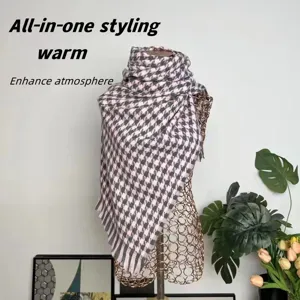 Detailed view of pink and black houndstooth cashmere-like scarf on a golden mannequin