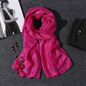 Macro view of a bright pink cotton linen scarf featuring an elegant shimmer texture