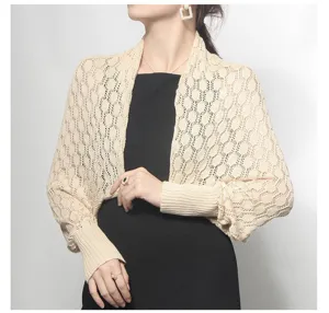 Detailed shot of a beige honeycomb hollow knit bolero with long cuffed sleeves.