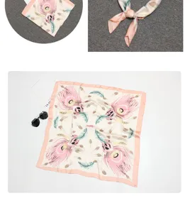 Detail view of a silky square scarf featuring elegant pink and green feather patterns.