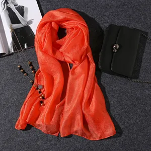 Macro shot of a vibrant orange lightweight scarf with shimmering pearlescent texture