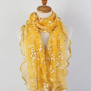 Detailed view showing the yellow floral print lace scarf with delicate ruffled wood ear edges