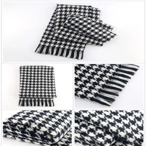 Detailed view of black and white houndstooth faux cashmere scarf showing soft texture.