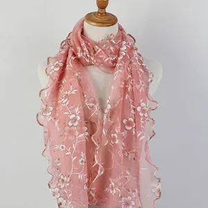 Close-up detail of the pink floral embroidery and ruffled lettuce edges on the scarf
