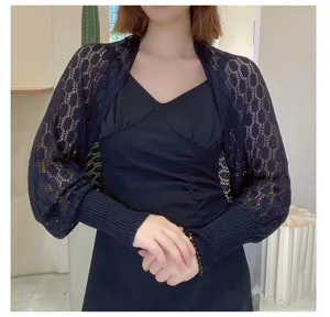 Detailed view of a black honeycomb hollow knit shawl bolero worn over a dress