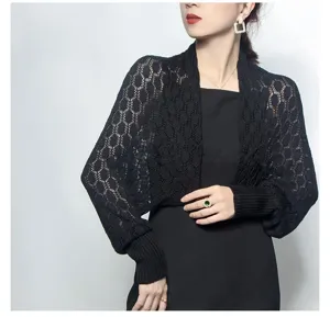 Close-up detail of black knitted honeycomb hollowed-out shawl shrug worn by a model